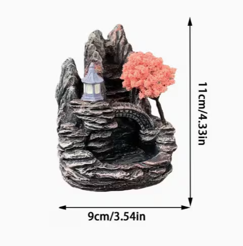 Decorative mountain-like incense burner with a small lamp and pink flowers, shown with dimensions on a white background.